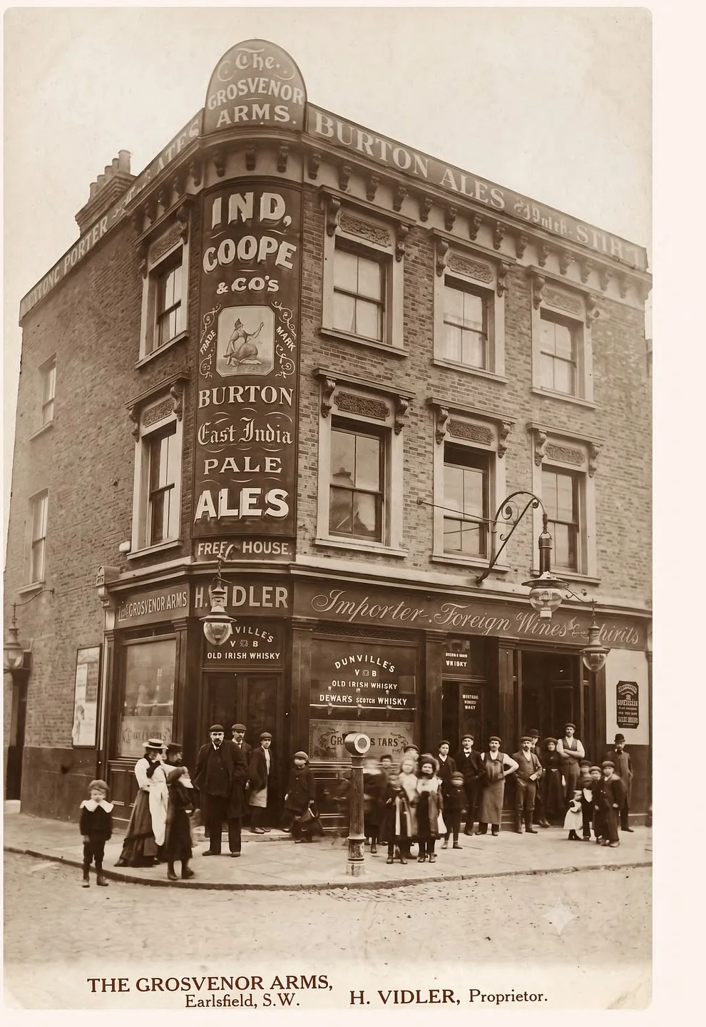A photograph from around 1900 of The Grosvenor Arms, Earlsfield, with the proprietor H. Vidler and a crowd of local residents outside