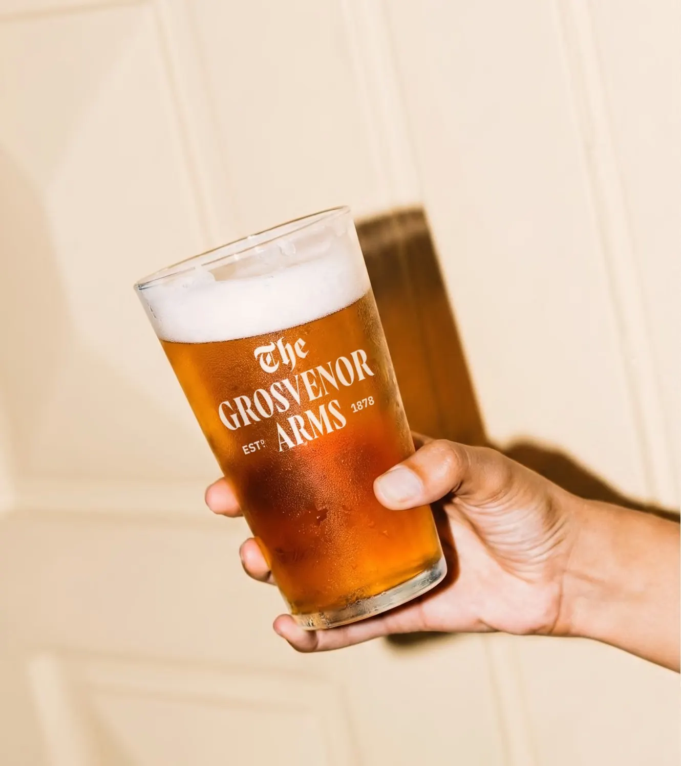 A pint of ale in a branded Grosvenor Arms glass
